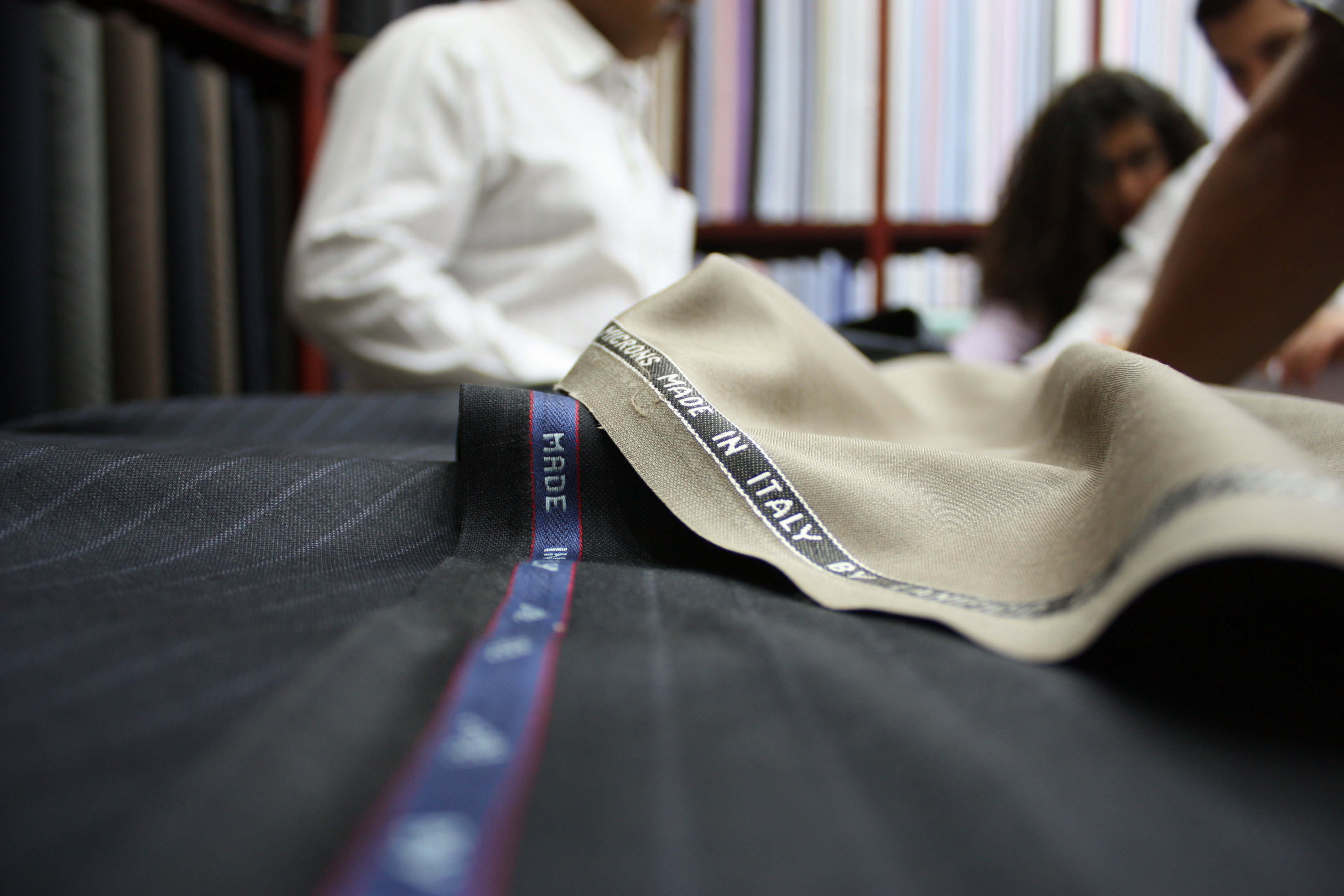Fabric consultation — tailor and client selecting cloth