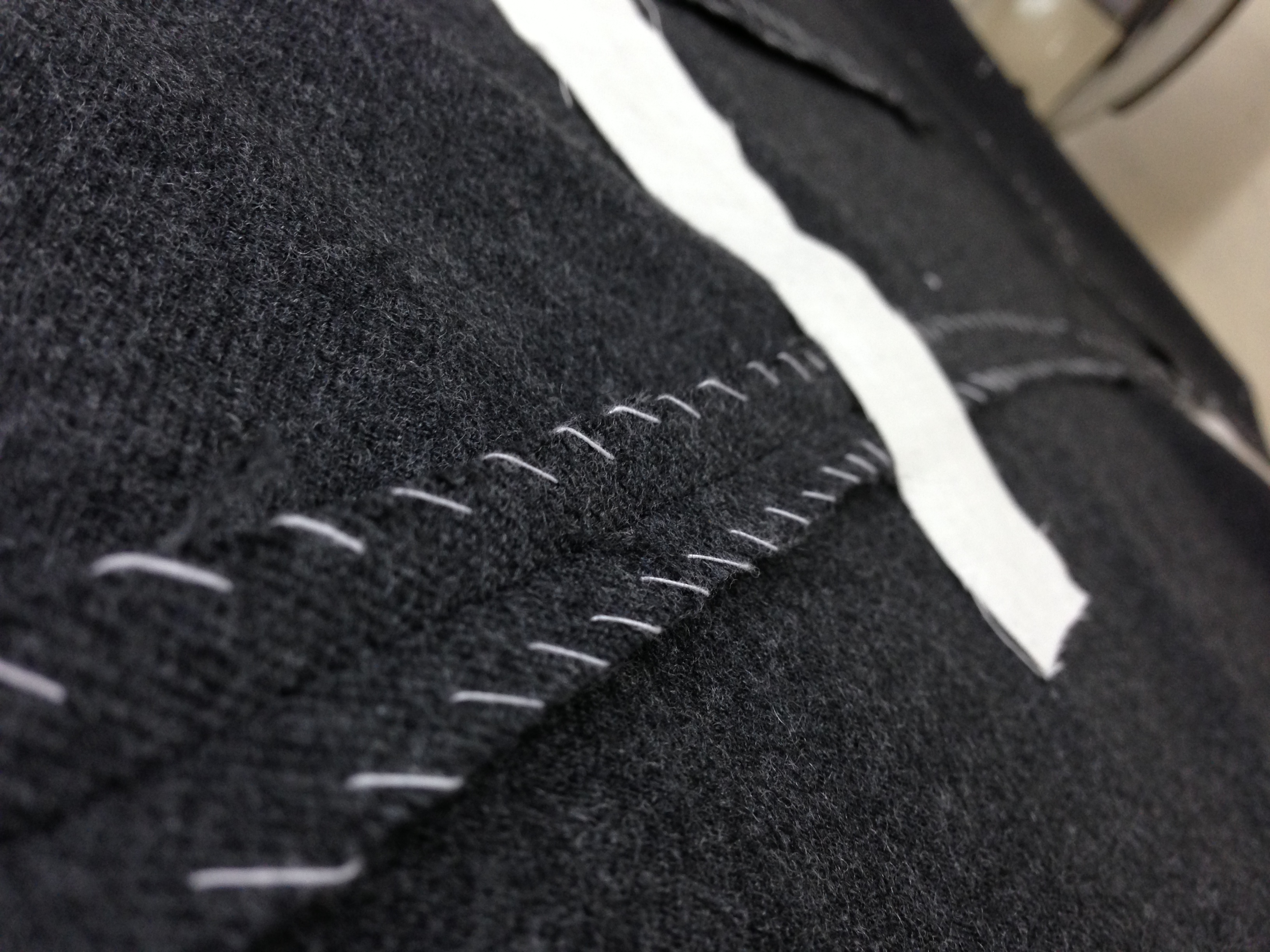 Hand pad-stitching on a bespoke jacket — the control room