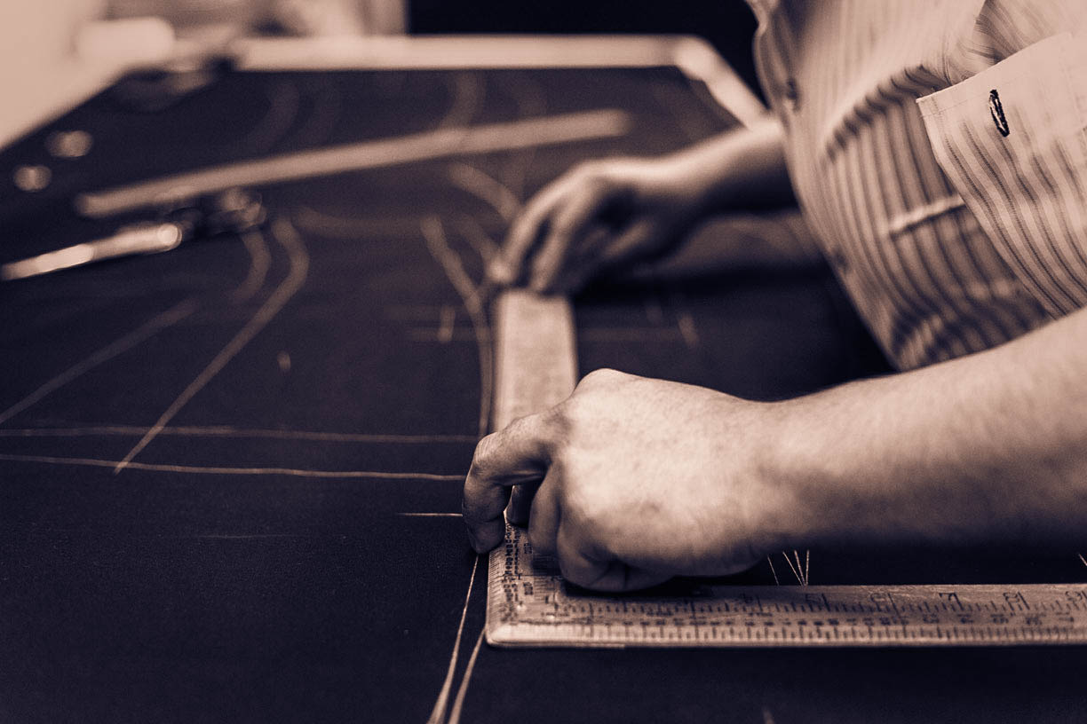 Master tailor drafting a pattern in the atelier