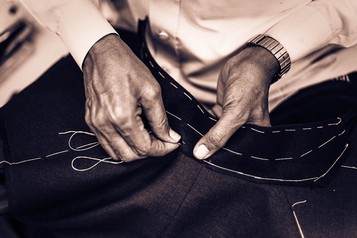Master tailor hand-stitching a garment